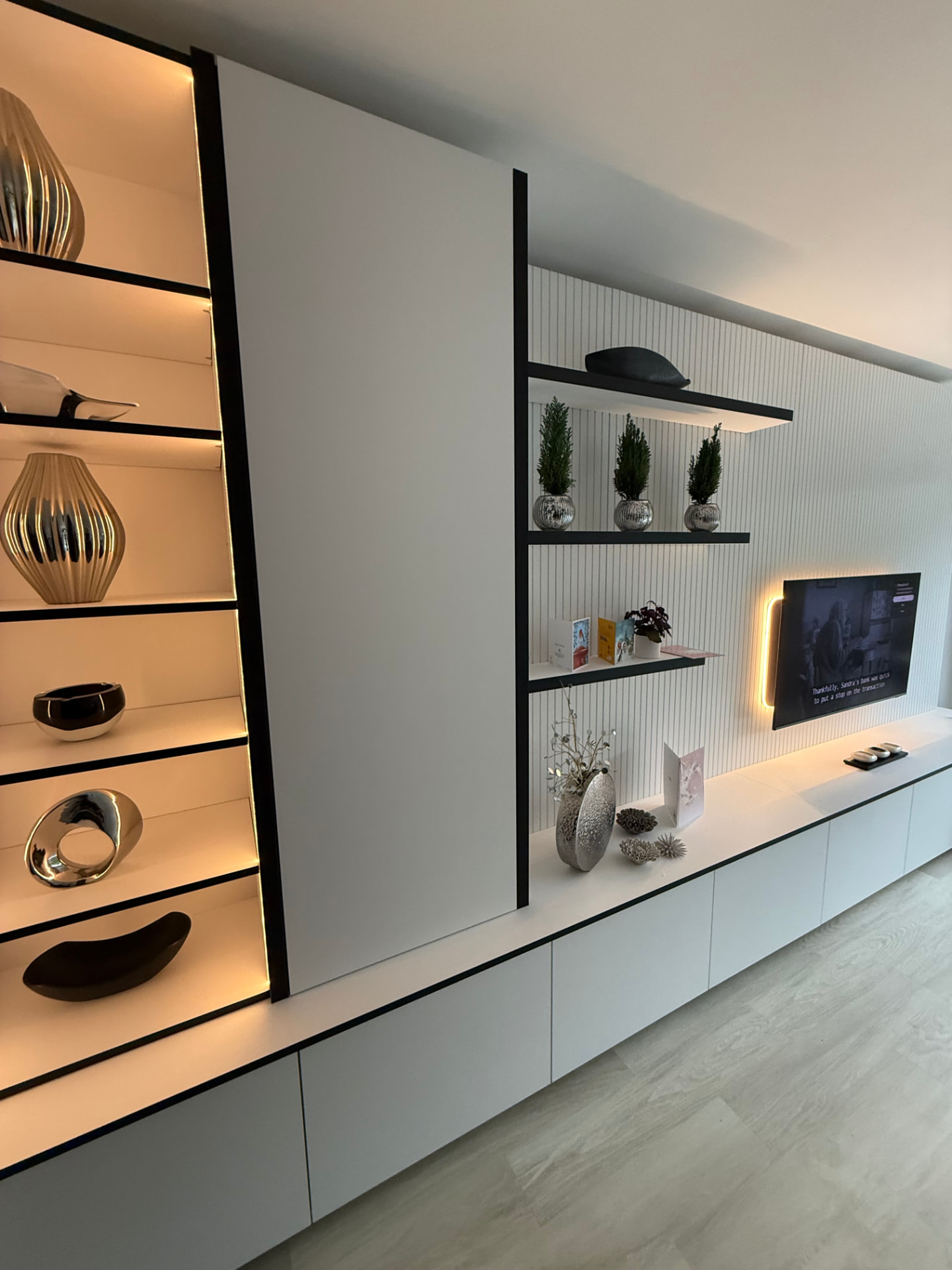 Handleless white media wall with lit display shelving and fluted panelling